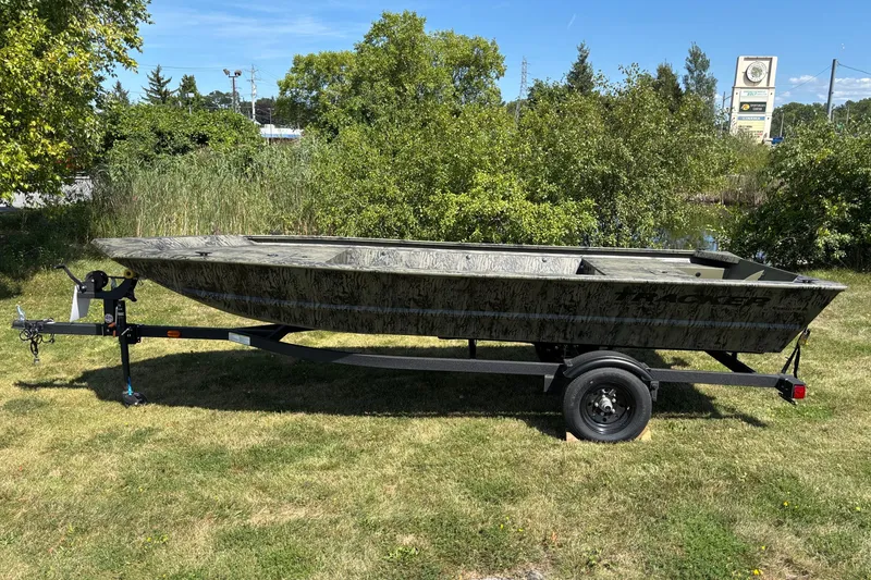 The Image of 2027 Tracker Grizzly 1648 Utility boat on trailer, parked on grassy area. - 0