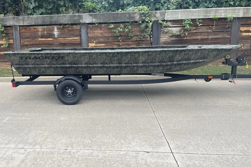 The Image of 2027 Tracker Grizzly 1648 Utility boat on trailer, parked on concrete driveway. - 0