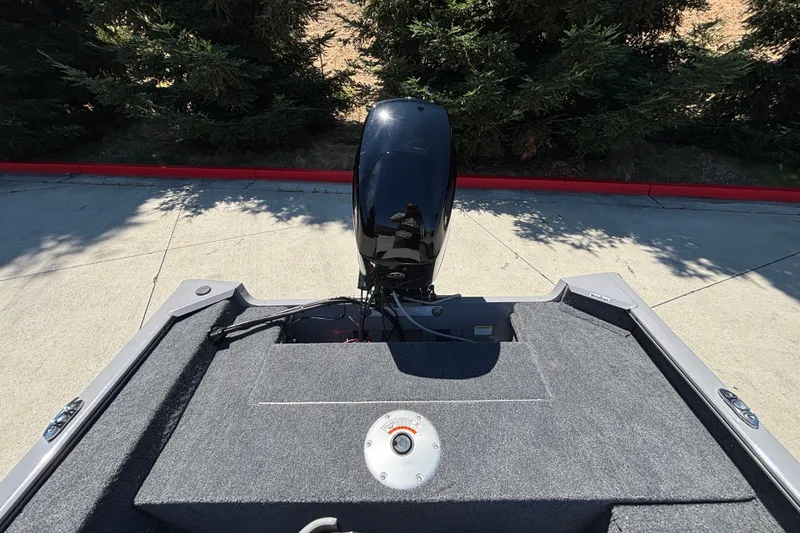 Slide: The Image of 2027 Tracker Super Guide V-16 SC boat with outboard motor, parked on concrete. - 23