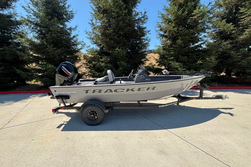 The Image of 2027 Tracker Super Guide V-16 SC boat on trailer, parked outdoors. - 0
