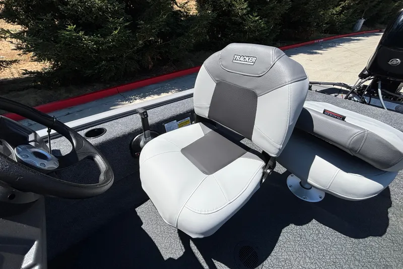 Slide: The Image of 2027 Tracker Super Guide V-16 SC boat seat, gray and black design, steering wheel visible. - 18