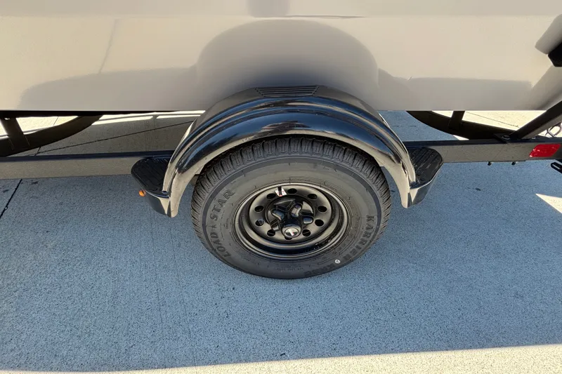 Slide: The Image of Trailer wheel of 2027 Tracker Super Guide V-16 SC on concrete surface. - 32