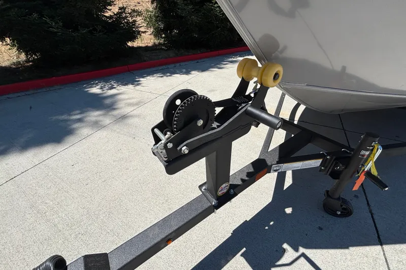Slide: The Image of Trailer hitch of 2027 Tracker Super Guide V-16 SC boat on pavement. - 36