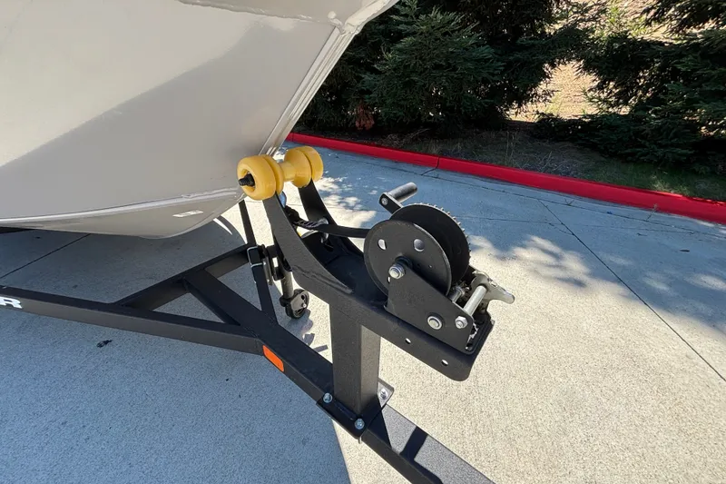 Slide: The Image of Trailer hitch and winch of 2027 Tracker Super Guide V-16 SC boat on pavement. - 37