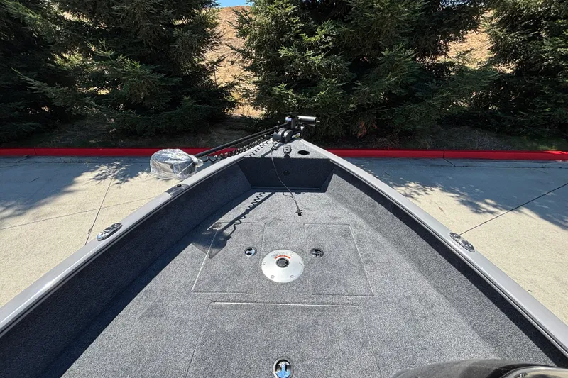 Slide: The Image of 2027 Tracker Super Guide V-16 SC boat interior with carpeted deck and trolling motor. - 28