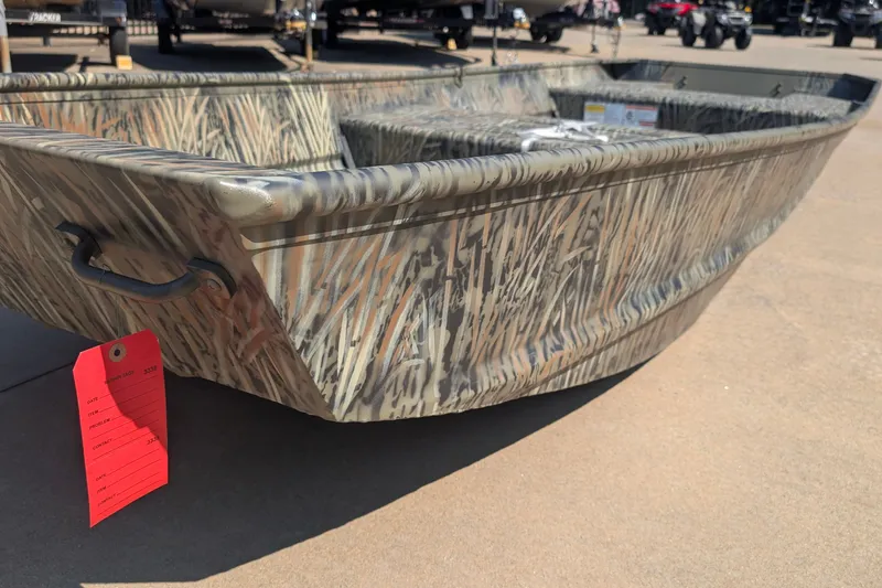 The Image of 2027 Tracker Grizzly 15 Jon boat with camouflage design on display outdoors. - 0