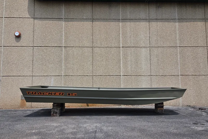 The Image of 2027 Tracker Grizzly 15 Jon boat displayed outdoors on wooden supports. - 0