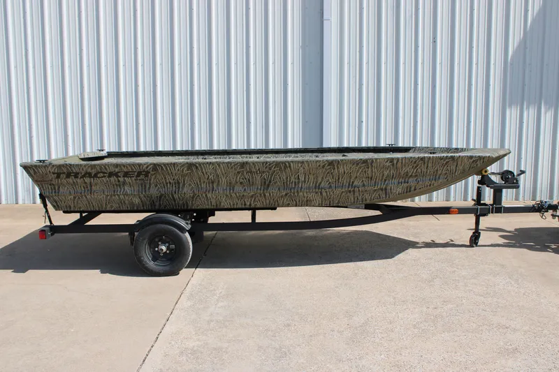 Slide: The Image of 2027 Tracker Grizzly 1648 Utility boat on trailer, camo design, parked outdoors. - 20
