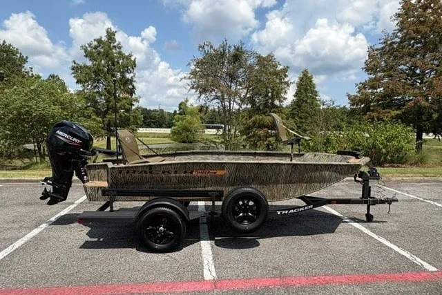 The Image of 2027 Tracker Grizzly 1553 Timber boat on trailer, parked outdoors under a cloudy sky. - 0