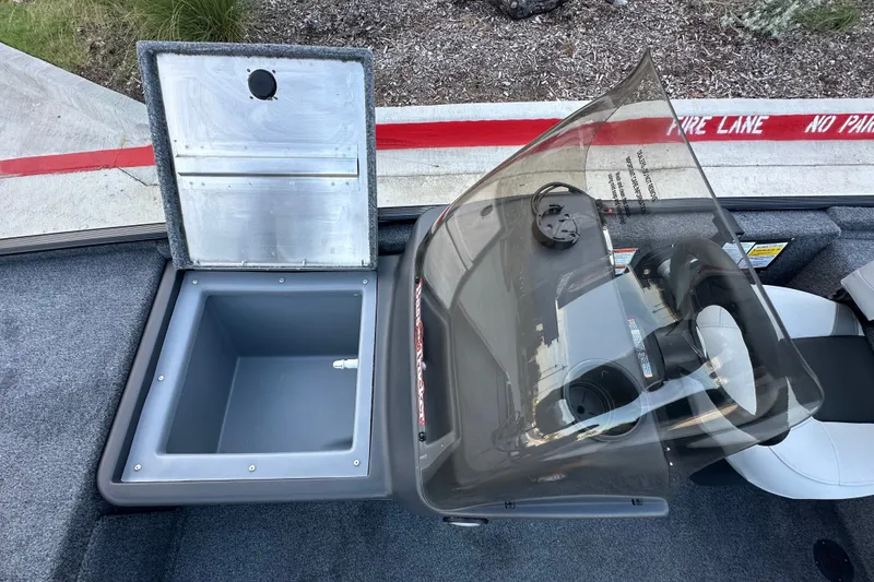 Slide: The Image of 2027 Tracker Bass Tracker Classic XL boat interior with open storage compartment and steering console. - 64