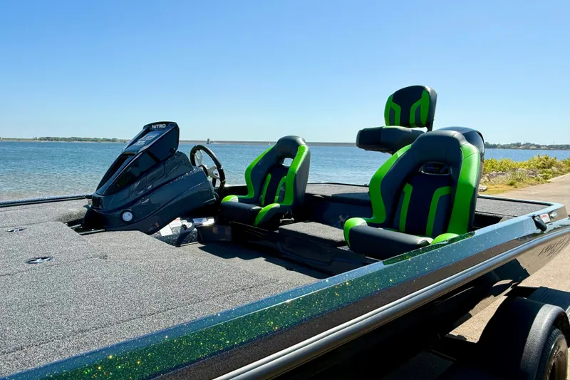 Slide: The Image of 2027 Nitro Z18 XL Pro boat with green-accented seats by the water. - 19