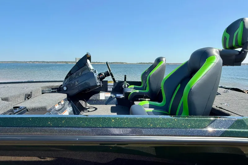 Slide: The Image of 2027 Nitro Z18 XL Pro boat interior with green-accented seats by the water. - 20