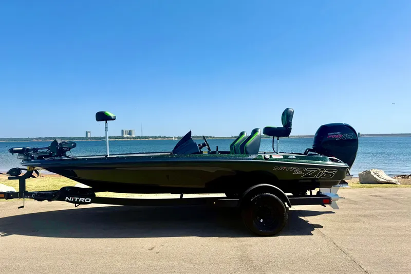 Slide: The Image of 2027 Nitro Z18 XL Pro boat by the water on a sunny day. - 2