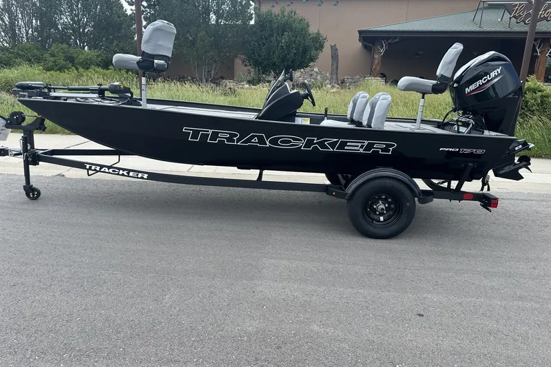 The Image of 2027 Tracker Pro 170 boat on trailer, parked on road, featuring Mercury engine. - 0