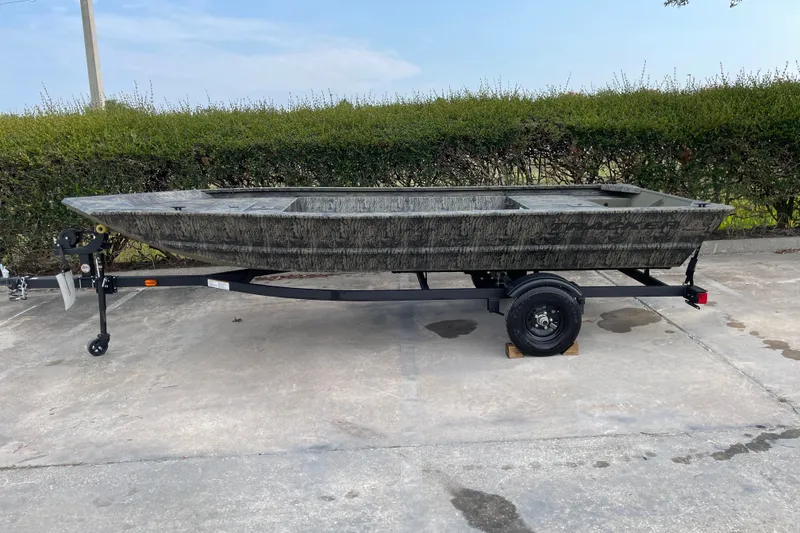 The Image of 2027 Tracker Grizzly 1648 Utility boat on trailer, parked outdoors. - 0