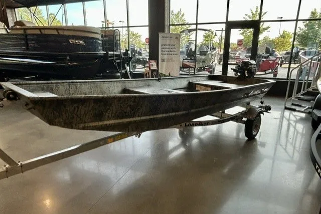 The Image of 2027 Tracker Grizzly 15 Jon boat on trailer in showroom, side view. - 0