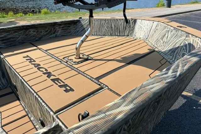 Slide: The Image of 2027 Tracker Grizzly 1553 Timber boat with camo design near a lake. - 13