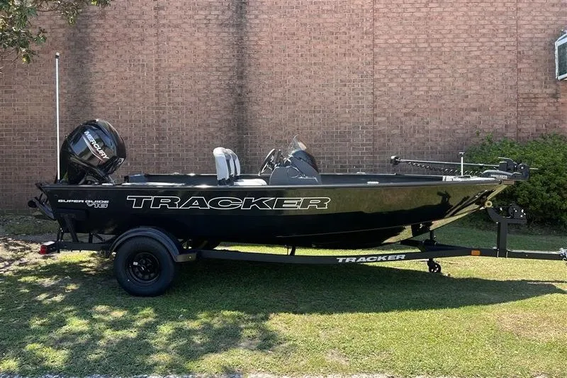 The Image of 2027 Tracker Super Guide V-16 SC boat on trailer, parked on grass. - 0