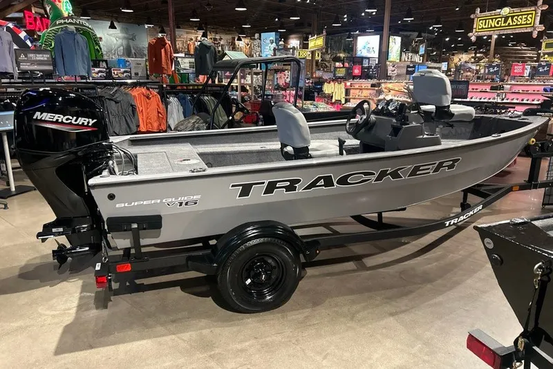 The Image of 2027 Tracker Super Guide V-16 SC boat displayed in a showroom with Mercury engine. - 0