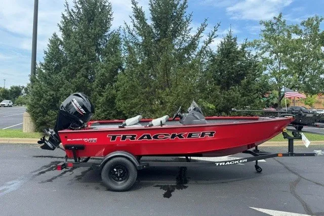 The Image of Red 2027 Tracker Super Guide V-16 SC boat on trailer, parked outdoors. - 0