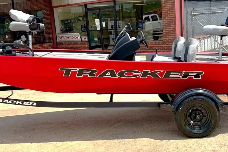 The Image of Red 2027 Tracker Pro 170 boat on trailer, parked outside a service department. - 0