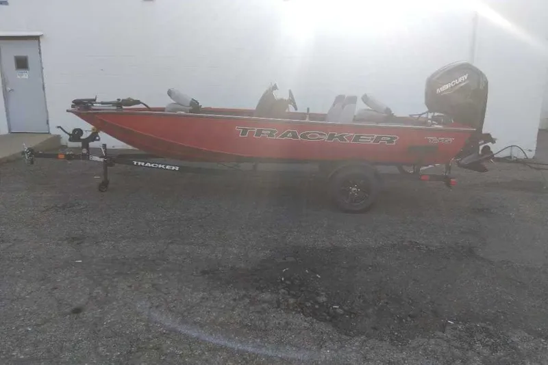 The Image of 2027 Tracker Pro Team 175 boat on trailer, parked outdoors, featuring Mercury outboard motor. - 0