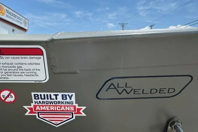 Slide: The Image of 2027 Tracker Grizzly 1648 Utility boat with "Built by Hardworking Americans" sticker and "All Welded" label. - 23