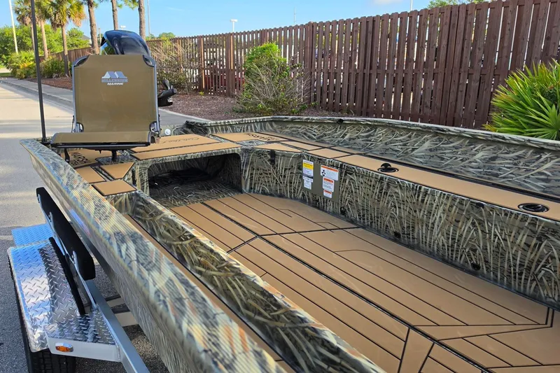 Slide: The Image of 2027 Tracker Grizzly 1756 T Marsh boat with camouflage design on a trailer. - 13