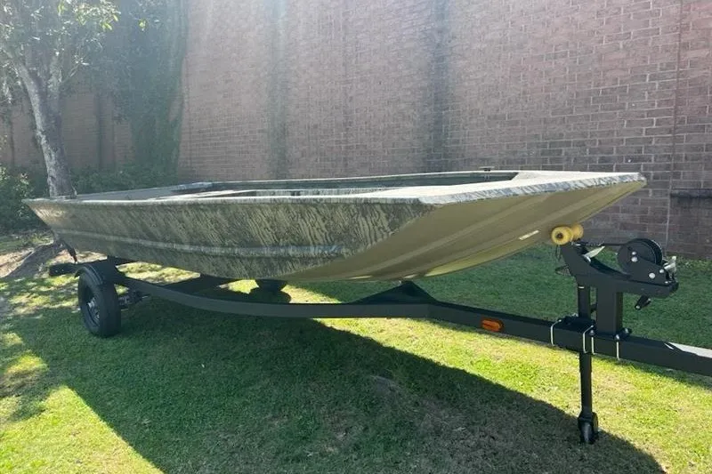 The Image of 2027 Tracker Grizzly 1648 Utility boat on trailer, parked on grass. - 0