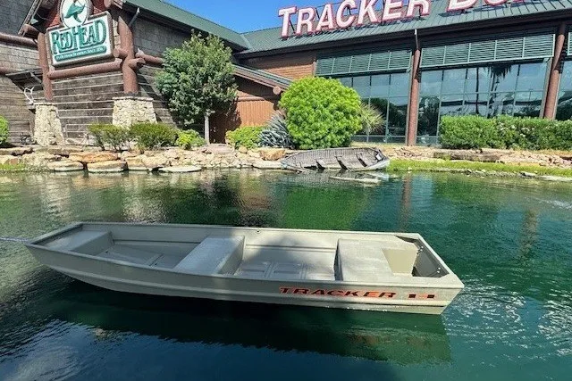 The Image of Tracker Grizzly 14 Jon boat in a pond outside a store, 2027 model. - 0