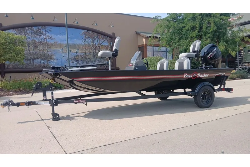 The Image of 2027 Tracker Bass Tracker Classic XL boat on trailer, parked outdoors. - 0