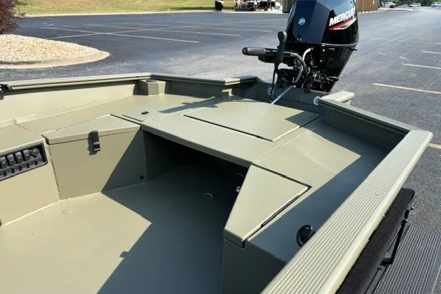 Slide: The Image of 2027 Tracker Grizzly 1553 Timber boat with Mercury outboard motor in a parking lot. - 17