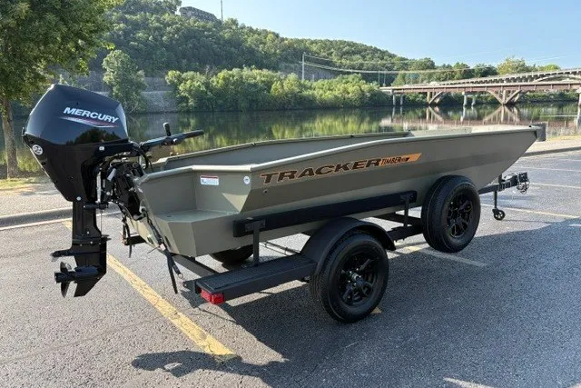 Slide: The Image of 2027 Tracker Grizzly 1553 Timber boat with Mercury engine, parked near a scenic river. - 15