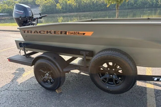 Slide: The Image of 2027 Tracker Grizzly 1553 Timber boat on trailer, parked near a scenic river. - 12