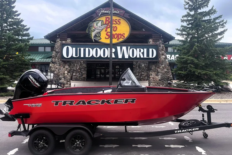 The Image of Red 2027 Tracker Pro Guide V-175 Combo boat displayed outside Bass Pro Shops Outdoor World. - 0