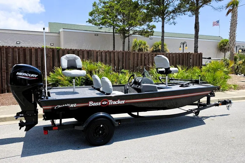 The Image of 2027 Tracker Bass Tracker Classic XL boat on trailer, featuring Mercury engine, parked outdoors. - 0