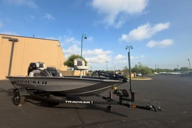 The Image of 2027 Tracker Pro Team 175 boat on trailer in parking lot under blue sky. - 0
