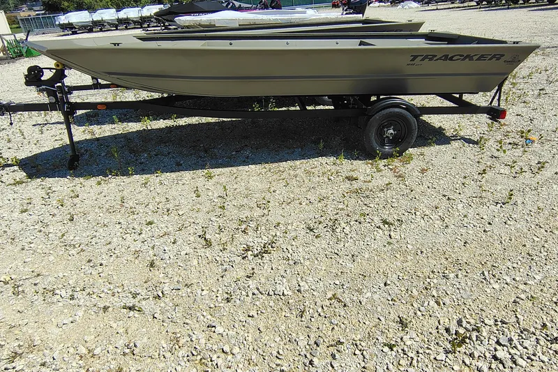 The Image of 2027 Tracker Grizzly 1648 Utility boat on trailer, parked on gravel surface. - 0