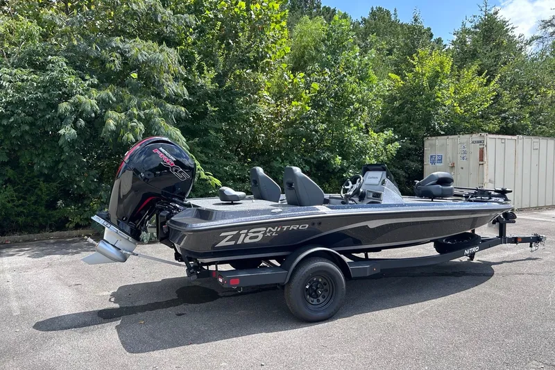 Slide: The Image of 2027 Nitro Z18 XL Pro boat on trailer, parked outdoors with lush greenery background. - 2
