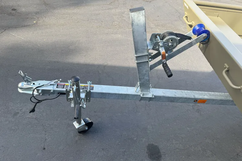 Slide: The Image of Trailer hitch and winch of 2027 Tracker Grizzly 15 Jon boat on pavement. - 26