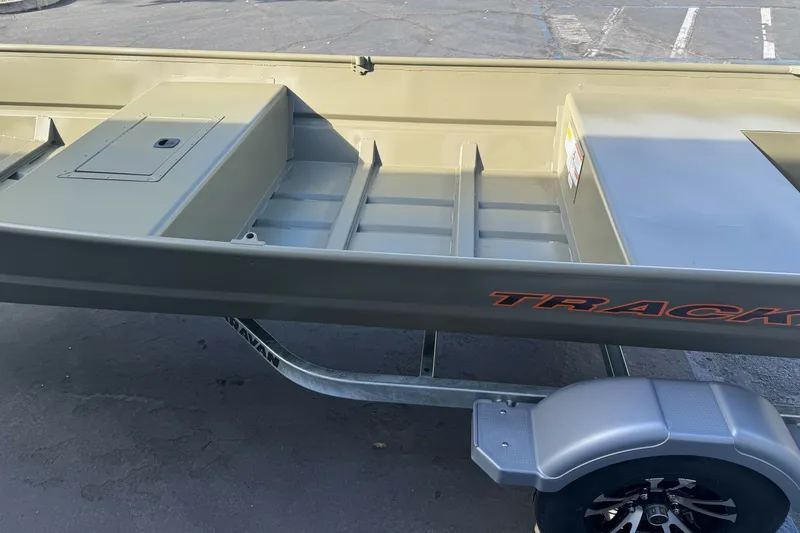 Slide: The Image of 2027 Tracker Grizzly 15 Jon boat on trailer, showcasing interior and branding. - 23