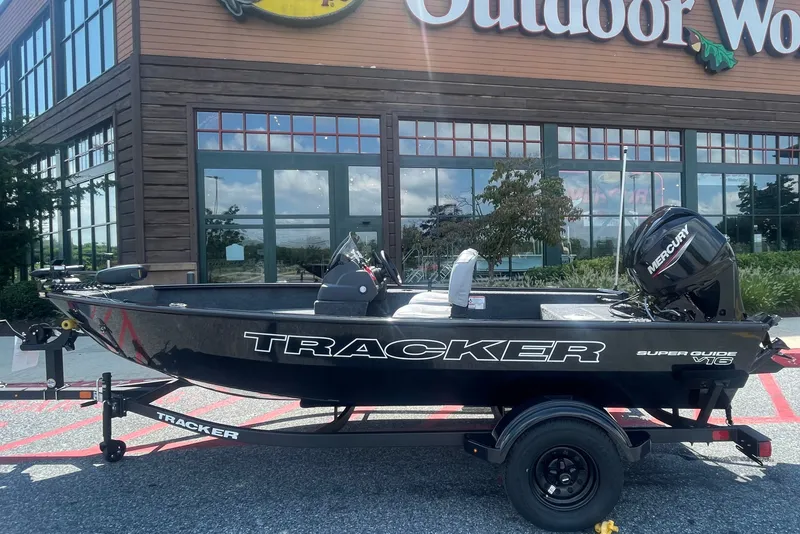 The Image of 2027 Tracker Super Guide V-16 SC boat displayed outside Outdoor World store. - 0