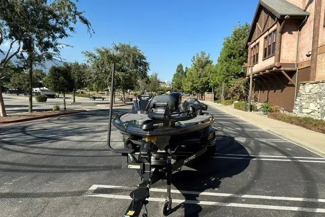 Slide: The Image of 2027 Nitro Z18 XL boat parked in a sunny, tree-lined urban area. - 3