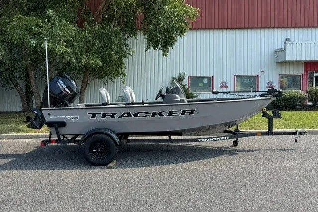 The Image of 2027 Tracker Super Guide V-16 SC boat on trailer, parked outdoors. - 0