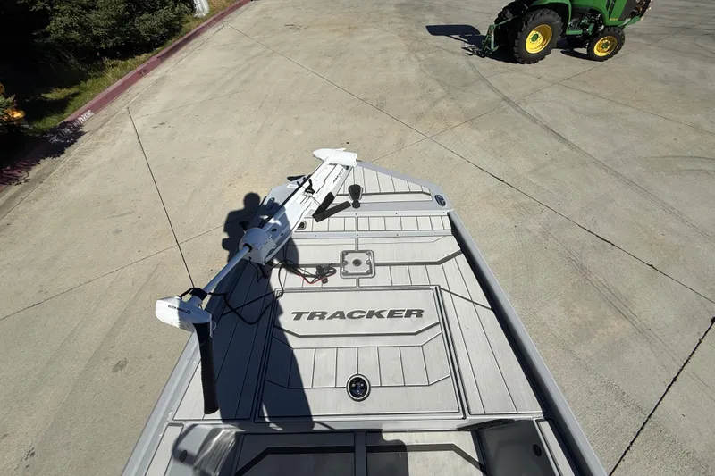 Slide: The Image of 2027 Tracker Bass Tracker Classic CC boat on concrete, with tractor in background. - 15