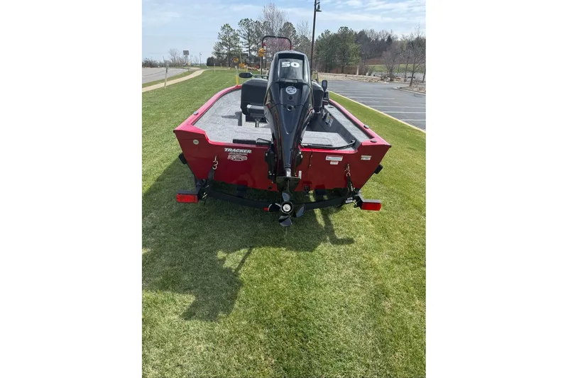 Slide: The Image of 2027 Tracker Super Guide V-16 SC boat with motor, parked on grass. - 13