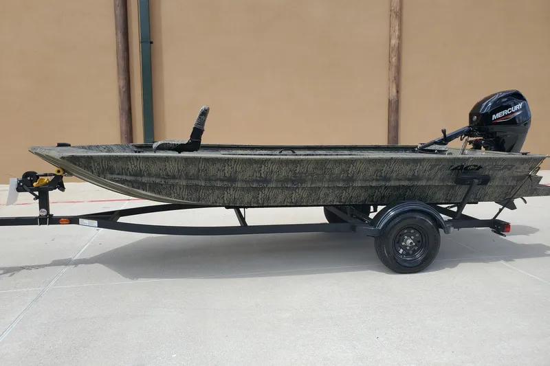 The Image of 2027 Tracker Grizzly 1654 T Sportsman boat on trailer, featuring Mercury outboard motor. - 0