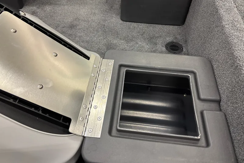 Slide: The Image of 2027 Tracker Bass Tracker Classic XL boat storage compartment with open lid and carpeted interior. - 21