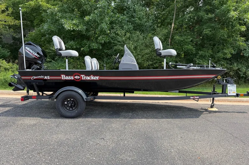 The Image of 2027 Tracker Bass Tracker Classic XL boat on trailer, parked outdoors. - 0
