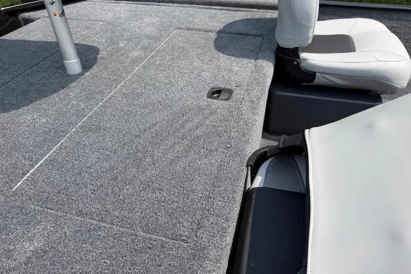 Slide: The Image of 2027 Tracker Bass Tracker Classic XL boat interior with gray carpet and white seating. - 14